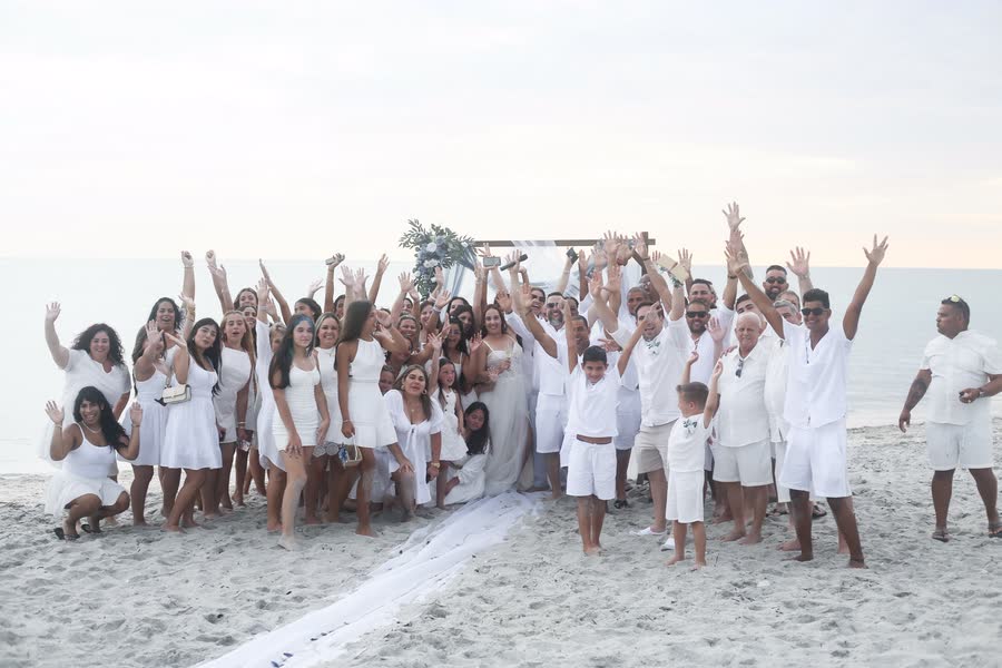 Large group of women celebrating on the beach at sunset during a photo event