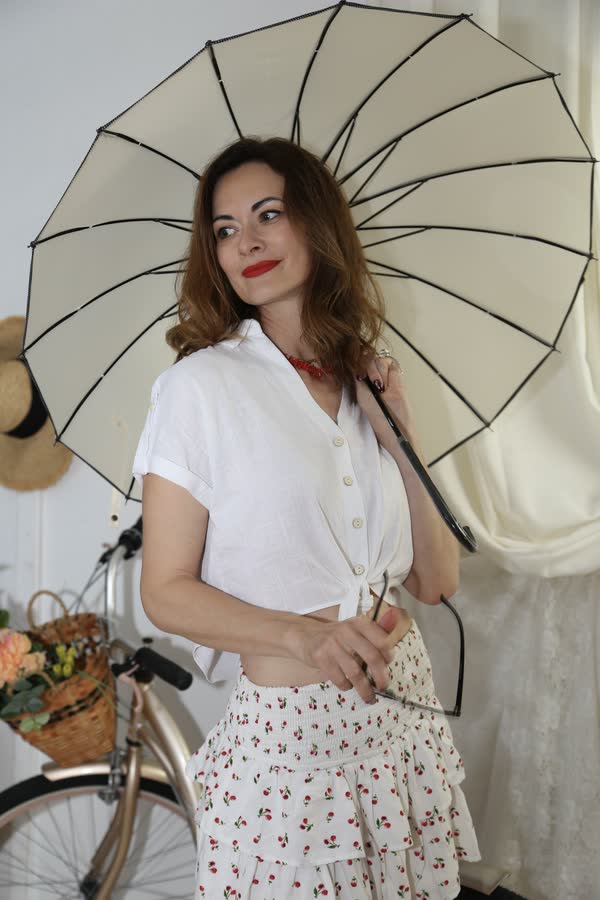 Woman with a lace parasol in vintage styling at a themed photo event
