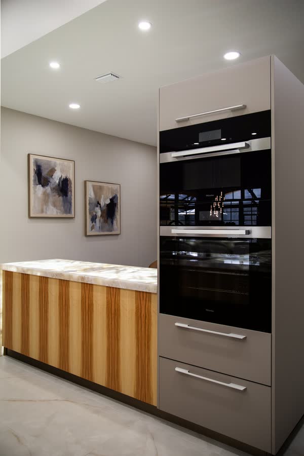 Wood-grain kitchen cabinetry with built-in double wall ovens