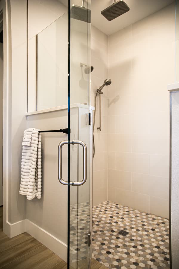 Glass walk-in shower with mosaic tile floor