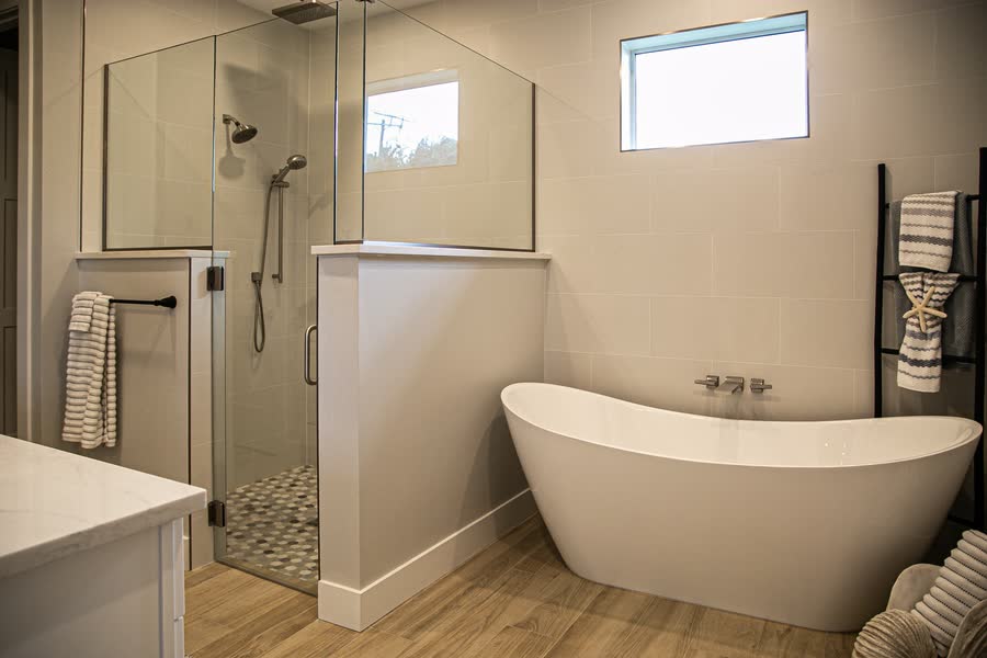 Freestanding soaking tub beside a walk-in shower