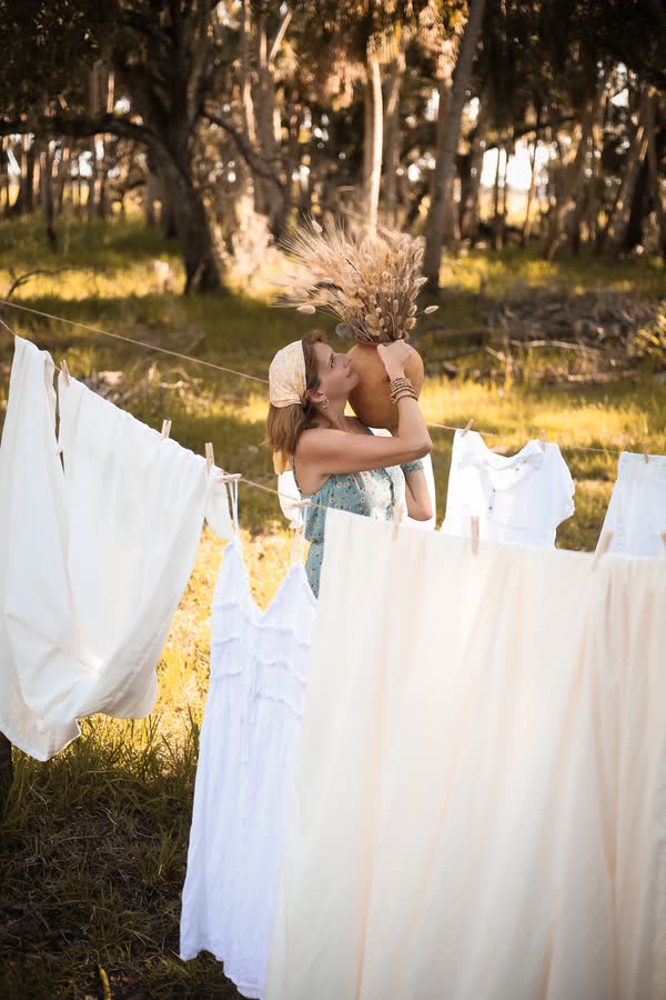 Couple photographed at golden hour among trees and flowing fabric