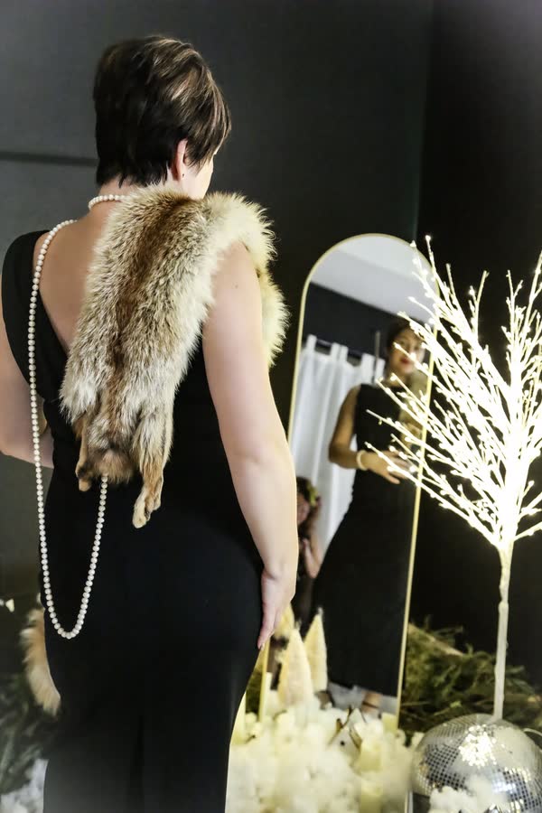 Fashion portrait from behind in a black gown with fur styling