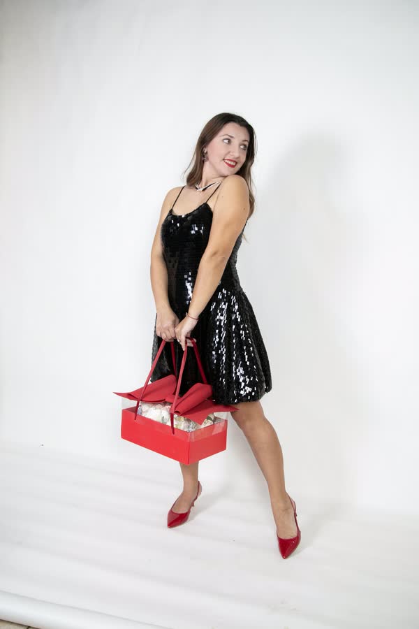 Full-length studio portrait of a woman in a black dress