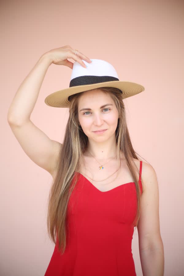 Studio portrait of a woman in a red dress and wide-brimmed hat