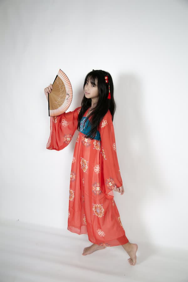 Themed portrait of a woman in a red silk robe with a folding fan